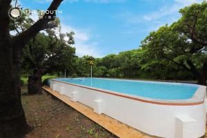 a large swimming pool in a park with trees at The South-Dawn in Hengchun