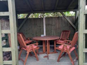 une table en bois et quatre chaises sur une terrasse couverte dans l'établissement Ferndale House-Huku Kwetu Luton -Spacious 4 Bedroom House - Suitable & Affordable Group Accommodation - Business Travellers, à Luton