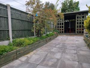 um jardim com um pátio e uma cerca em Ferndale House-Huku Kwetu Luton -Spacious 4 Bedroom House - Suitable & Affordable Group Accommodation - Business Travellers em Luton