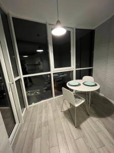 a table and chairs in a room with windows at Апартаменти Люкс 4 in Khmelnytskyi