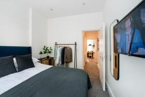Preston Apartments في بريستون: غرفة نوم بسرير وتلفزيون بشاشة مسطحة