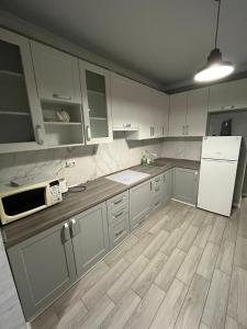 a kitchen with white cabinets and a white refrigerator at Апартаменти Люкс 4 in Khmelnytskyi