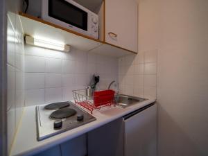 uma pequena cozinha com um fogão e um lavatório em Appartement tout équipe wifi à 6 min St Charles em Marselha