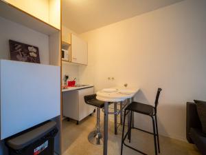 uma pequena cozinha com uma pequena mesa e cadeiras em Appartement tout équipe wifi à 6 min St Charles em Marselha