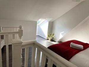 uma escada com uma cama vermelha num quarto em Ferndale House-Huku Kwetu Luton -Spacious 4 Bedroom House - Suitable & Affordable Group Accommodation - Business Travellers em Luton
