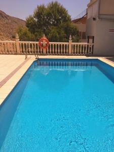 a large blue swimming pool next to a fence at Habitación con vistas in Aguadulce