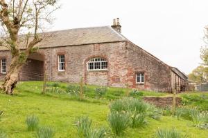 an old brick building in a field of grass at Old Leckie Farmstay in Stirling