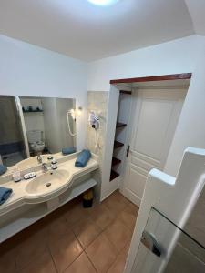 a bathroom with a sink and a large mirror at Studio Cannelle Vue Mer Village Vacances Sainte Anne in Sainte-Anne