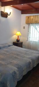 サンベルナルドにあるComplejo Tío Tatoのベッドルーム1室(テーブルの上にランプ付きのベッド1台付)