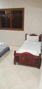 Ce lit se trouve dans un dortoir doté d'un sol blanc. dans l'établissement Dar fatima, à Azrou