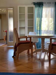 uma sala de jantar com uma mesa de vidro e cadeiras em Am Birkenhain em Titisee-Neustadt