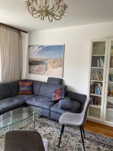 uma sala de estar com um sofá azul e uma mesa de vidro em Am Birkenhain em Titisee-Neustadt