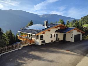 een huis met een zonnedak op een oprit bij Apart Verena in Ramsau im Zillertal