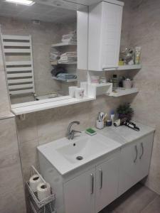 La salle de bains est pourvue d'un lavabo blanc et d'un miroir. dans l'établissement 150 m2 flat with high speed WiFi 100 mbps, perfect home office in the city center!, à Seyhan