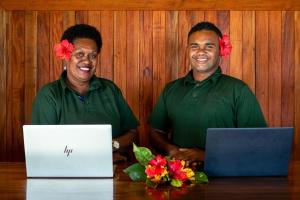 two men sitting at a table with a laptop at Waya Island Resort in Yalombi +61 photos