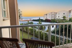 a balcony with two chairs and a view of the ocean at Seaside Stay - Beachfront/ Backup Inverter/ Housekeeping in Ballito