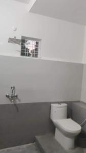 uma casa de banho branca com um WC e uma janela em Independent 2-Room with Kitchen Homestay em Dehradun