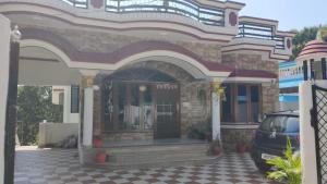um edifício com um carro estacionado em frente em Independent 2-Room with Kitchen Homestay em Dehradun