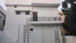 um edifício branco com uma escada ao lado em Independent 2-Room with Kitchen Homestay em Dehradun