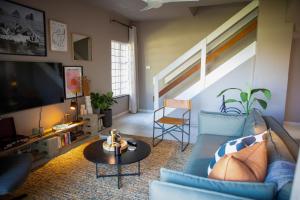 Seaside Stay - Beachfront/ Backup Inverter/ Housekeeping في باليتو: غرفة معيشة مع أريكة زرقاء وتلفزيون