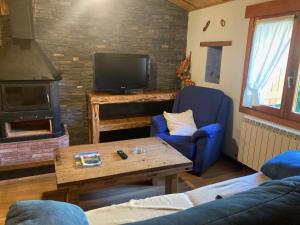 a living room with a couch and a table and a tv at Casa Lueza in Alueza