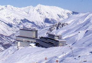 a building on top of a snow covered mountain at Appartement duplex aux Ménuires 4 personnes in Les Menuires