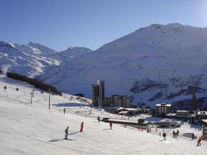 a group of people skiing on a snow covered mountain at Appartement duplex aux Ménuires 4 personnes in Les Menuires