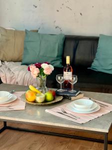 einen Tisch mit einem Obstteller und einer Flasche Wein in der Unterkunft ArT Apartment Near Paradise Mall & Metro Station in Sofia