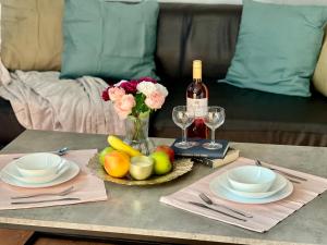 einen Tisch mit einem Obstteller und einer Flasche Wein in der Unterkunft ArT Apartment Near Paradise Mall & Metro Station in Sofia
