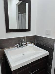 a bathroom with a white sink and a mirror at Cantares Adults Only in Cancún