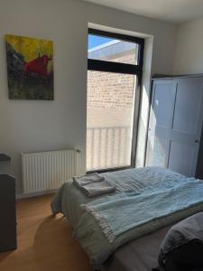 - une chambre avec un lit et une grande fenêtre dans l'établissement Leon Duren, à Düren