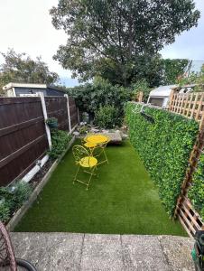 a small backyard with a yellow table and chairs at Beach retreat in Prestatyn