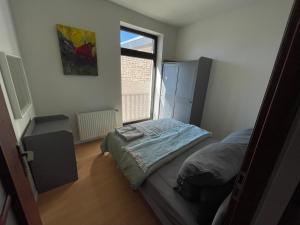 a small bedroom with a bed and a window at Leon Duren in Düren - Eifel
