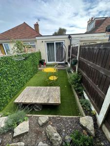 a backyard with a bench and a table and a fence at Beach retreat in Prestatyn