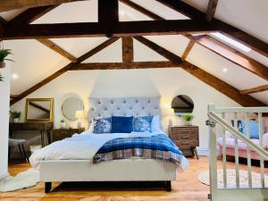 una camera con letto in una stanza con soffitti in legno di Stunning 3-Bed Cottage Hot Tub Wi-Fi Parking ad Appleby