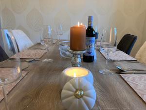 un tavolo con una candela e una bottiglia di vino di Stunning 3-Bed Cottage Hot Tub Wi-Fi Parking ad Appleby