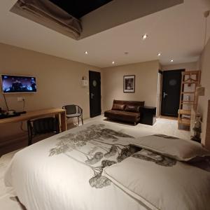 ein Schlafzimmer mit einem großen weißen Bett und einem Sofa in der Unterkunft Serenity Indepedent Suite near to Disneyland & Paris in Bussy-Saint-Georges