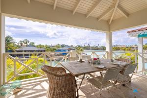 a table and chairs on a porch with a view of the ocean at Marina view apartments in Kralendijk
