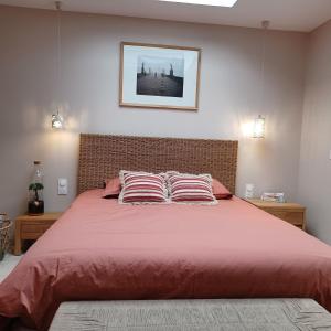 ein Schlafzimmer mit einem großen roten Bett mit zwei Kissen in der Unterkunft Serenity Indepedent Suite near to Disneyland & Paris in Bussy-Saint-Georges