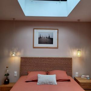 ein Schlafzimmer mit einem Bett mit einem Bild an der Wand in der Unterkunft Serenity Indepedent Suite near to Disneyland & Paris in Bussy-Saint-Georges