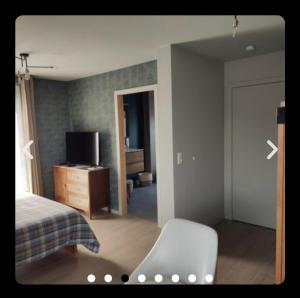 a bedroom with a bed and a chair and a television at Housedurbuy 2 in Durbuy