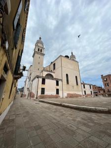 un grande edificio bianco con una torre dell'orologio su una strada di Ninette Home a Venezia