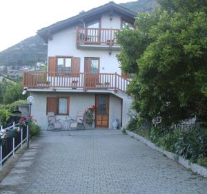 a white house with a balcony and a patio at VILLA ADRY Mon Reve Holidays in Aosta
