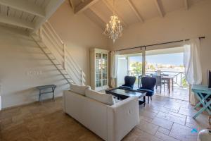 a living room with a couch and chairs and a table at Marina view apartments in Kralendijk