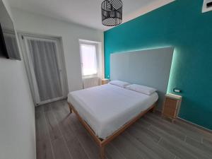 - une chambre avec un lit et un mur vert dans l'établissement Stone House, à San Maurizio dʼOpaglio