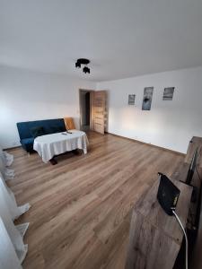 a living room with a blue couch and wooden floors at Apartament Maria 