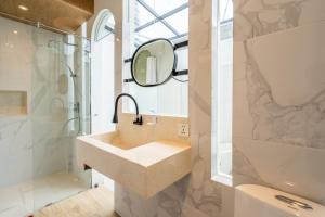 bagno con lavandino, doccia e specchio di Luxury Villa Belvedere Bali in Seminiak a Legian