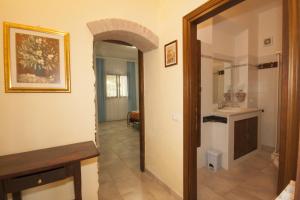 a hallway leading to a bathroom with a sink and a mirror at Agriturismo La Gazzella in Cura Nuova +13 photos