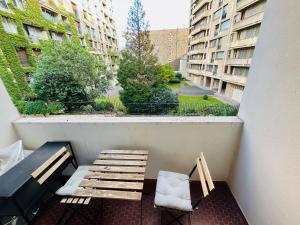 un balcón con banco, silla y edificios en Dream Dwell Paris -Studio with Balcony 800m to Trocadéro and Tour Eiffel, en París