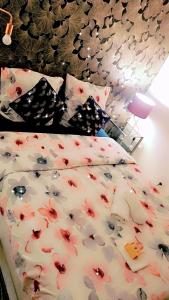a bed with a comforter with flowers on it at Cosy SM in Bois-Colombes
